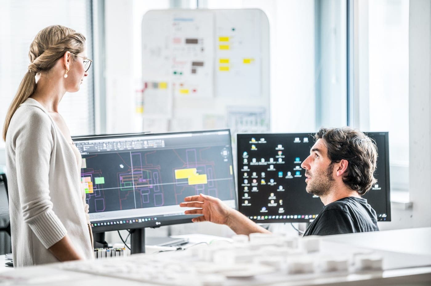 Zwei Kolleg:innen besprechen einen CAD-Plan am Arbeitsplatz bei DELTA